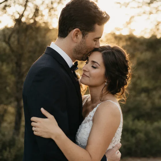 Bride and groom embracing at sunset.
